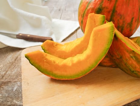 Pumpkin on the chopping block in preparation for cooking.