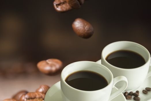 Cup of coffee and coffee beans on a wooden table.