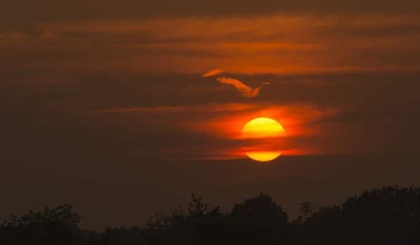 Bright big sun on the sky with clouds