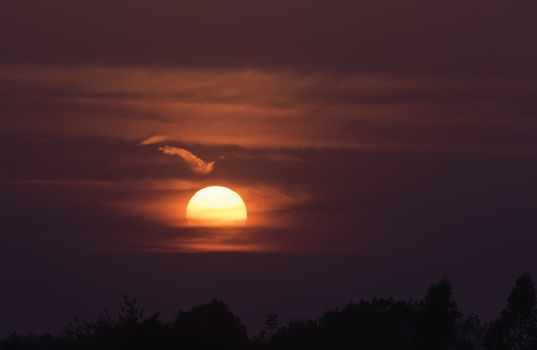 Bright big sun on the sky with clouds