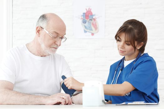 Doctor measuring blood pressure of male senior patient