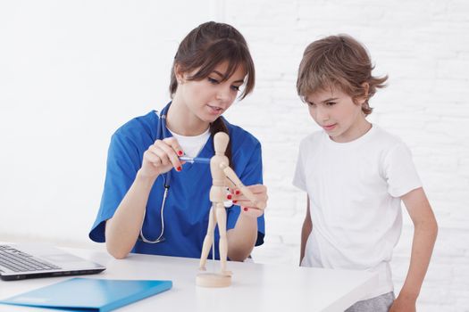 Doctor explain medicine to child using wooden doll