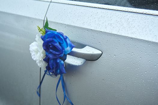 Flower decorations on the wedding car handle.