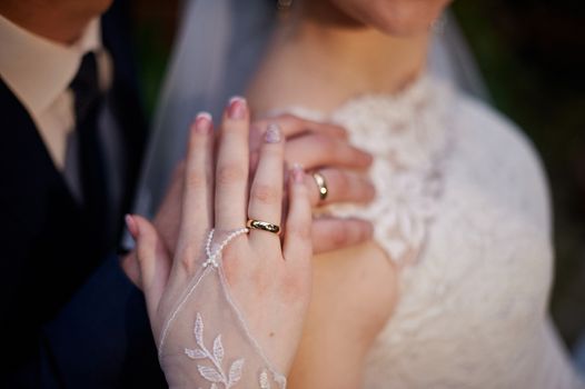 bride and groom show hands with wedding gold rings.