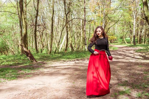 mysterious woman with a sickle in spring forest