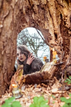 mystical woman looks in the mirror near a tree at the spring forest