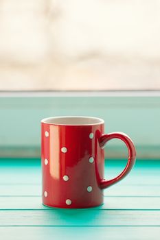 Red cup in white peas on a windowsill