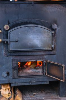 Interior fireplace in a corner with firewood and ax in an old country house