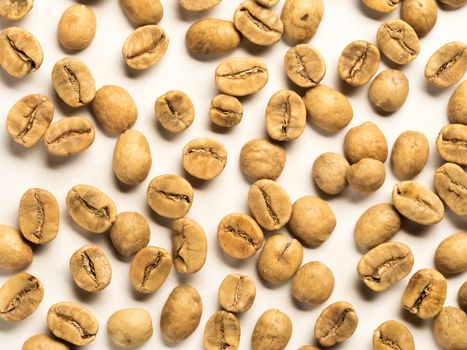 White coffee beans on white background. Top view or flat lay. Closeup. Image with natural colors