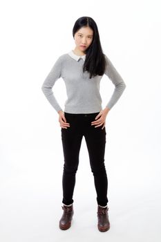 Chinese teenager standing with hands on hips, looking serious