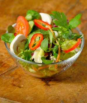 Tasty fresh salad on wooden table