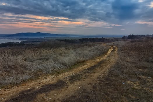 beautiful landscape on rural road at cloudy sunset