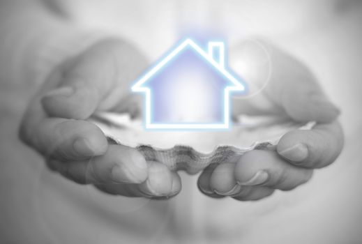 Hand holding a house over an oyster shell 