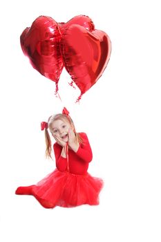 Delighted girl in red with heart-shaped balloons over white