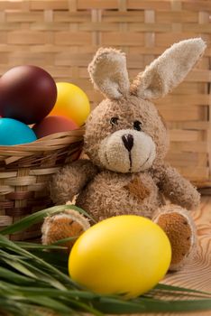 small Easter bunny with beautiful colored eggs in the basket