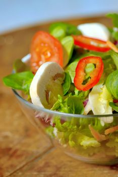 Tasty fresh salad on wooden table