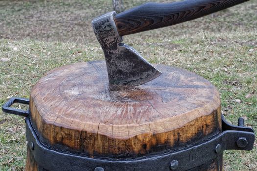 The axe stuck in the chopping block for splitting wood