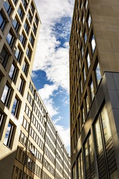 Skyscraper with square windows and sky with clouds.