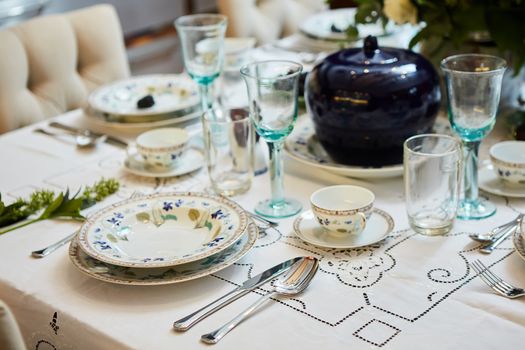 Decorated table ready for dinner. Beautifully decorated table set with flowers, candles, plates and serviettes for wedding or another event in the restaurant.