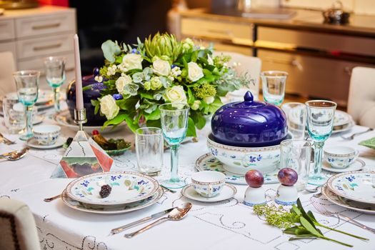 Decorated table ready for dinner. Beautifully decorated table set with flowers, candles, plates and serviettes for wedding or another event in the restaurant.