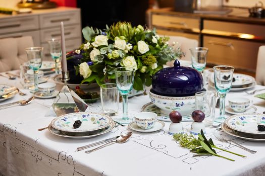 Decorated table ready for dinner. Beautifully decorated table set with flowers, candles, plates and serviettes for wedding or another event in the restaurant.