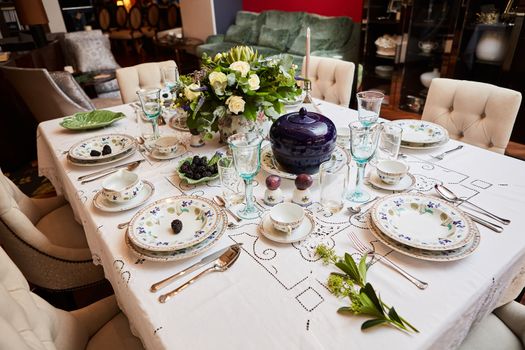 Decorated table ready for dinner. Beautifully decorated table set with flowers, candles, plates and serviettes for wedding or another event in the restaurant.