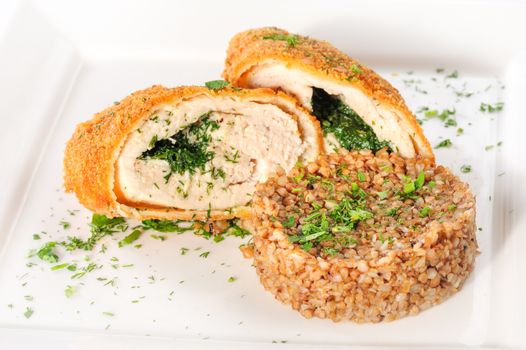 Big cutlet of turkey meat with garnish made of buckwheat cereal