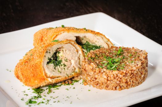 Big cutlet of turkey meat with garnish made of buckwheat cereal