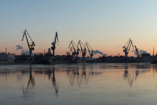 Silhouettes portal cranes reflection on water port St. Petersburg