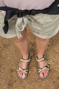View down at female feet in tracking sandals. Trekking outdoors tourist adventure.
