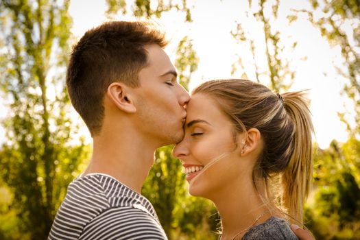 Portrait of a happy young couple in love and giving a kiss