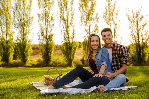 Shot of a beautiful couple on the park making a picnic and having fun