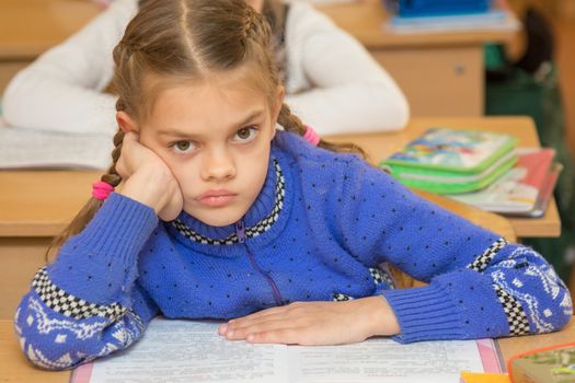 First grader to read the lesson and looking at teacher listens carefully to his