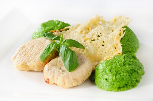 Steamed meatballs with green potato-broccoli puree and basil leaves