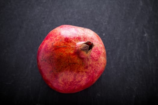 Fresh Red Pomegranate placed on a stone plate