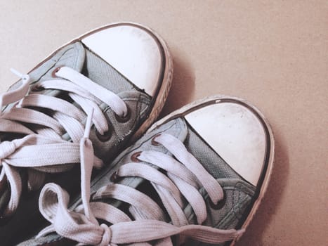 Dirty shoes top view of blue sneakers display on brown background. Vintage effect.