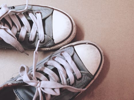 Dirty shoes top view of blue sneakers display on brown background. Vintage effect.