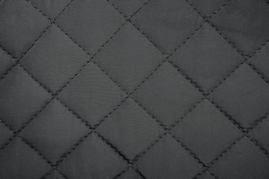 Cloth in rhombus. Quilted synthetic fabric texture background.