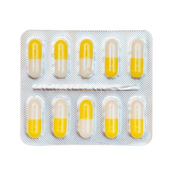 Blister pack of yellow and white capsules isolated on white background.