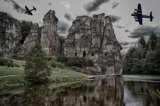 Two old combat aircraft, bomber from the World War II flying over the Externsteine. Rock formation in the Teutoburg Forest, Germany, North Rhine Westphalia.