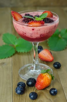 Raspberry smoothie with fresh berries on a wooden table