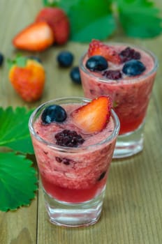 Raspberry smoothie with fresh berries on a wooden table