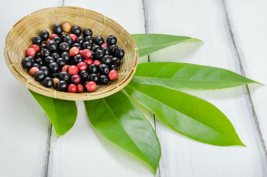 Thai Blueberry in bamboo basket over wooden background , still life