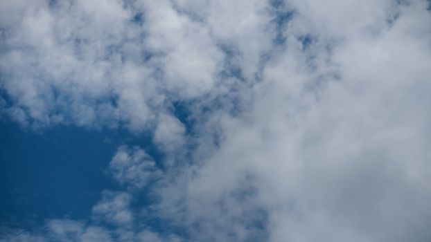 White fluffy clouds on a blue sky background