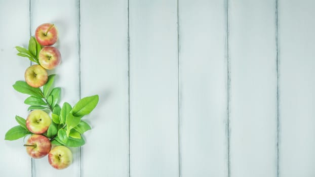 Top view red and yellow apple with leaves on white wooden background with free space for text