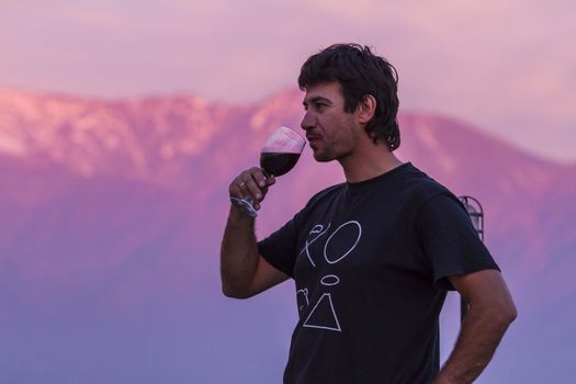 Man, drinking wine on the peak of the mountain
