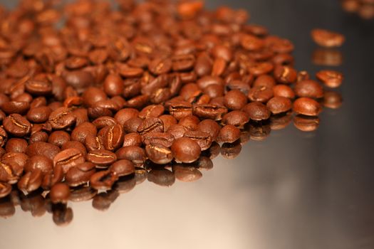 Selections of coffee beans scatted across a mirror