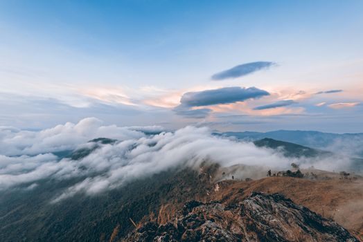 Vintage style beautiful landscape nature of sunrise on peak mountain with cloud fog and sky in winter at Phu Chi Fa Forest Park, Chiang Rai, Thailand, on Sienna-Blue color two tone