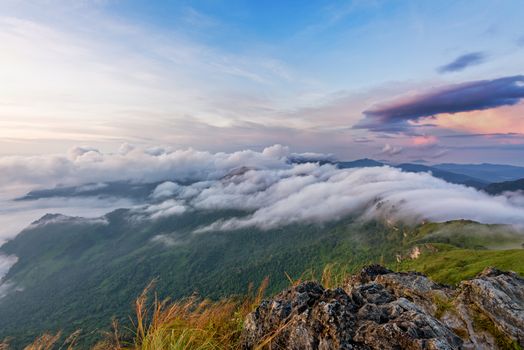 Beautiful landscape nature during sunrise on peak mountain with cloud fog and bright colors of sky in winter at Phu Chi Fa Forest Park is a famous tourist attraction of Chiang Rai Province, Thailand