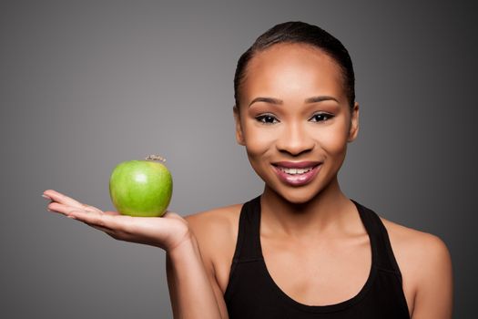 Beautiful healthy happy smiling black asian woman with apple in hand.